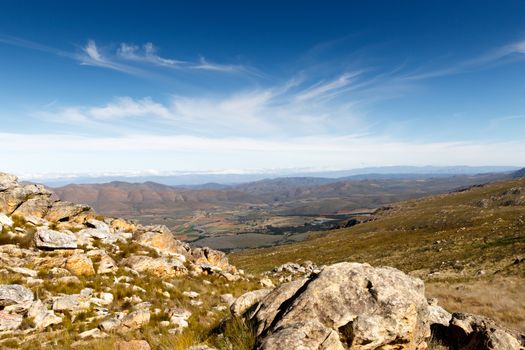 In the middle of The Swartberg Pass looking down at a green valley looking onto a plato