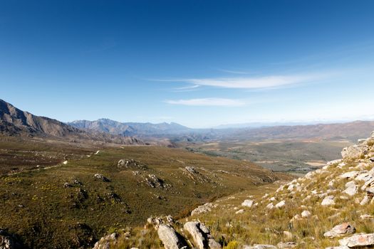 Huge valley overlooking the swartberg mountains with blue skies and green fields