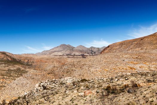 Beautiful clouds and mountains overlooking the barren landscape.