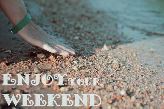 Woman's hand touching beach sand surface on vintage style