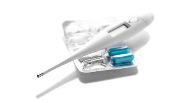 electronic thermometer and tablets on a white background 