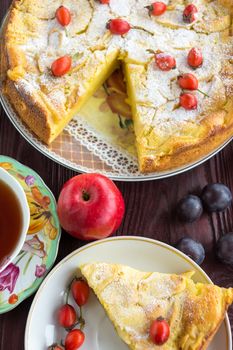 The photograph depicts an apple pie with berries