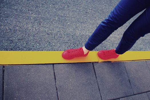 Red sneakers on yellow road line in vintage style