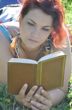 Woman in a meadow reading a book