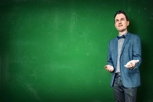 Man in a jacket teaching on a green chalkboard