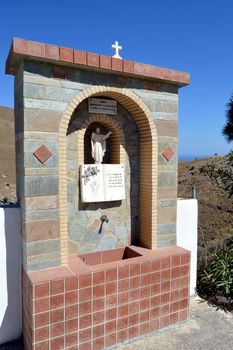 Brick-built fountain with a statue of Jesus Christ above.