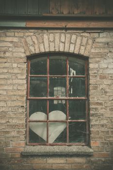 Forgotten love heart in a window on an old building