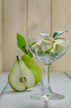 Slice of green pear in glass over white background