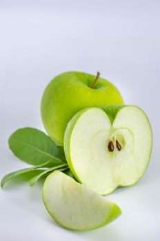 Ripe green apple with leaf and slice on a white background