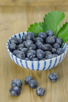 Blueberries in a bowl on a wooden background