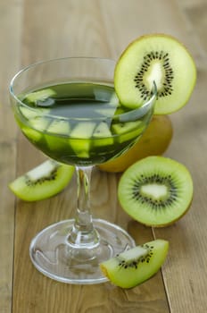 glass of kiwi juice with fresh fruits on wooden table