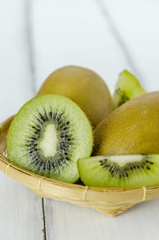 kiwi fruit and sliced with bamboo basket on wooden background