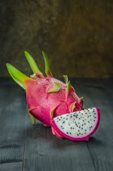 Ripe Dragon fruit or Pitaya with slice on wooden background , still life