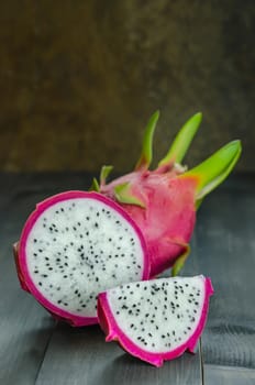 Ripe Dragon fruit or Pitaya with slice on wooden background , still life