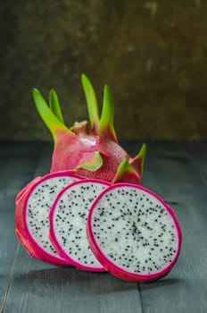 Ripe Dragon fruit or Pitaya with slice on wooden background , still life