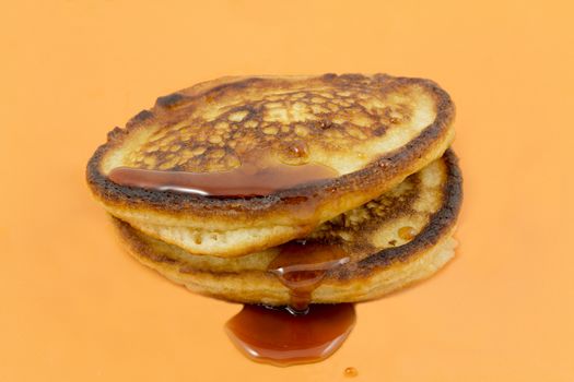 Closeup of lush fritters with honey on a yellow background