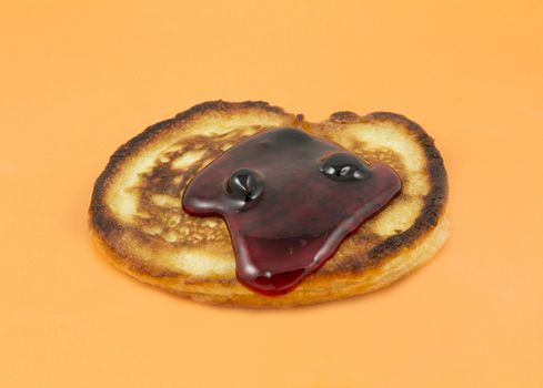 Closeup of lush pancakes with jam on a yellow background