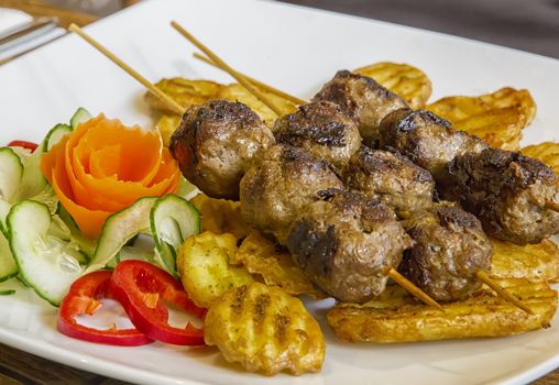 Grilled meat skewers with garnish, close up view