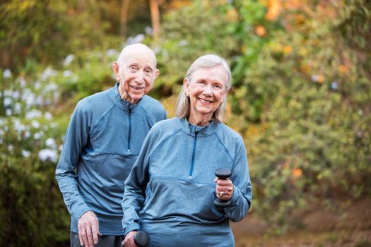 Cheerful fit man and woman standing outside in garden