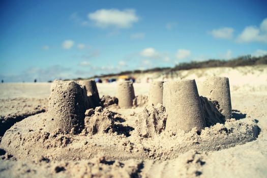 Sand castle on the beach with blue sky background