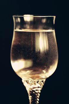 Sparkling water like champagne in a glass isolated on black