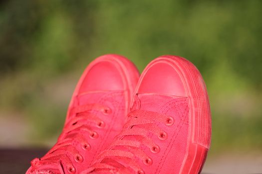 Red sneakers on green blured defocused background