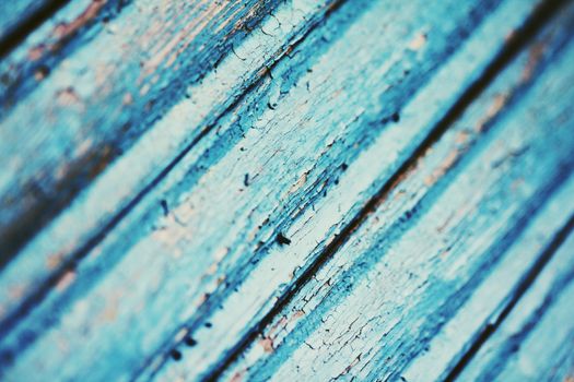 Cracked paint on blue wooden surface close up photo