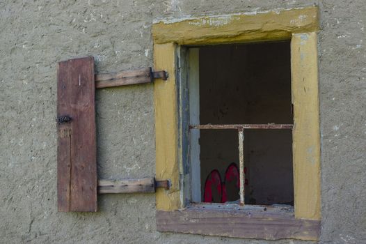 an old open broken window on wall