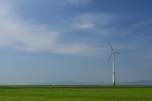 meadow with Wind power turbines generating electricity