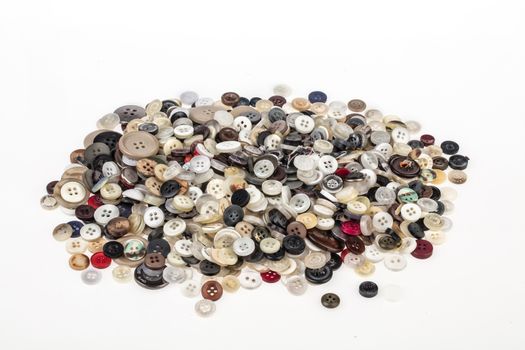 Many sewing buttons on an isolated studio background