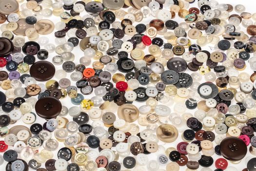 Many sewing buttons on an isolated studio background
