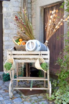 Wagon of wooden side dish with a milk can and flowers to dry.