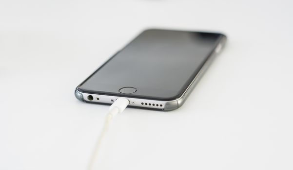 a black smartphone connected for a recharge