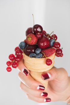 hand holding fresh berries in wafer
