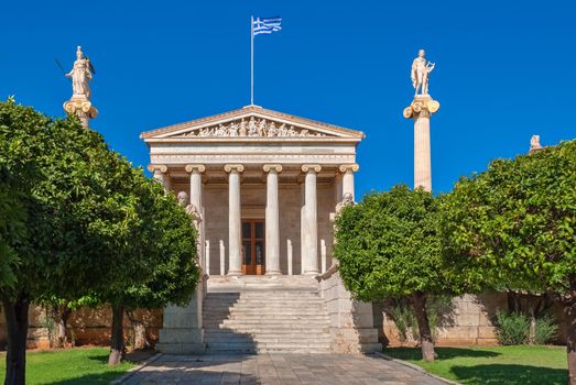 The facade of Athens Academy of Sciences with the main staircase and the statues of Apollo and Athena on high columns.