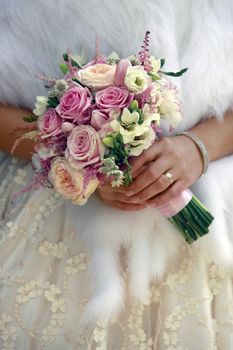 The bride holds a wedding bouquet