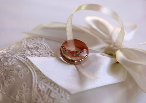 Wedding rings on a white satiny fabric