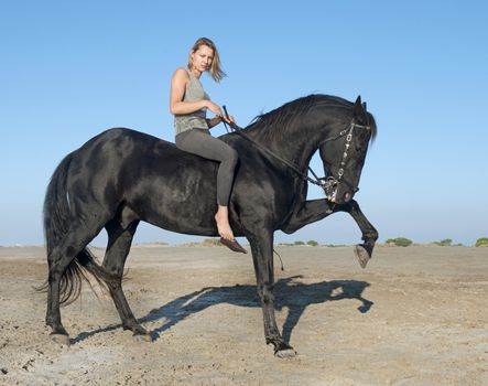 horse woman make dressage with her stallion on the beach