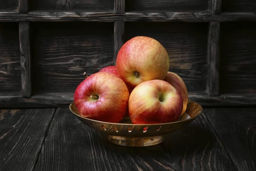 Dish of apples on dark background.Rustic style.Dark key