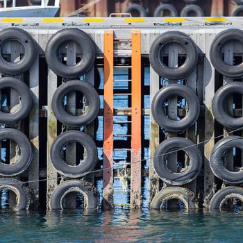 Old wooden mooring wall with car tires