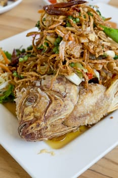 Deep fried fish with herb salad (Thai dish and healthy food)