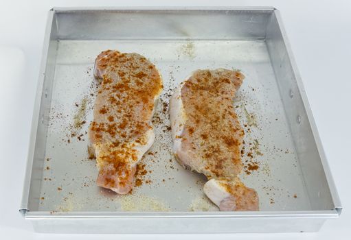 Raw pork fillet with spices, Paprika, Pepper in baking tin