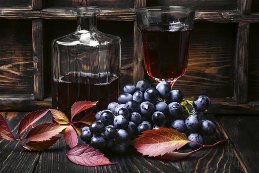 Young red wine in the glass from the autumn harvest of grapes.Dark key