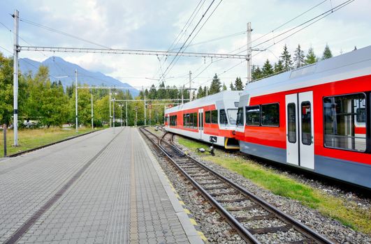 Railway station Strbske pleso with commuter electric train at platform in High Tatras.