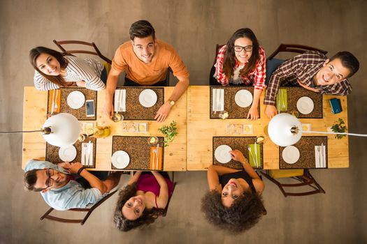 Group of people toasting and looking happy at a restaurant