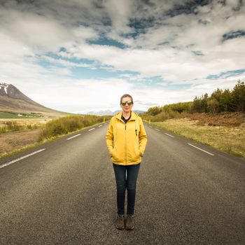 Outddor portrait of a woman in the middle of a beautiful road