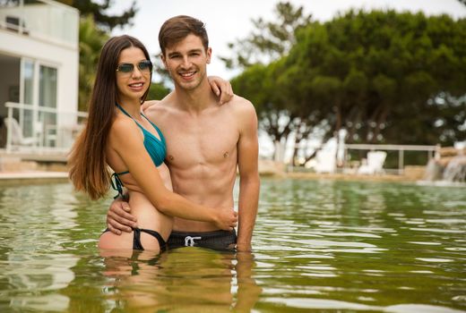 Young couple inside the pool and having fun
