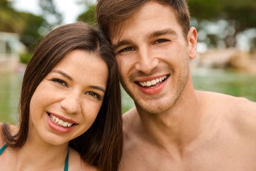 Portrait of a young couple embraced inside the pool