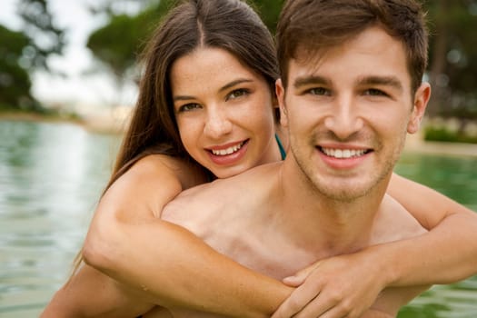 Portrait of a young couple embraced inside the pool