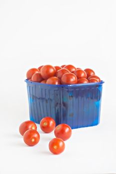 blue plastic box full of tomatoes isolated.